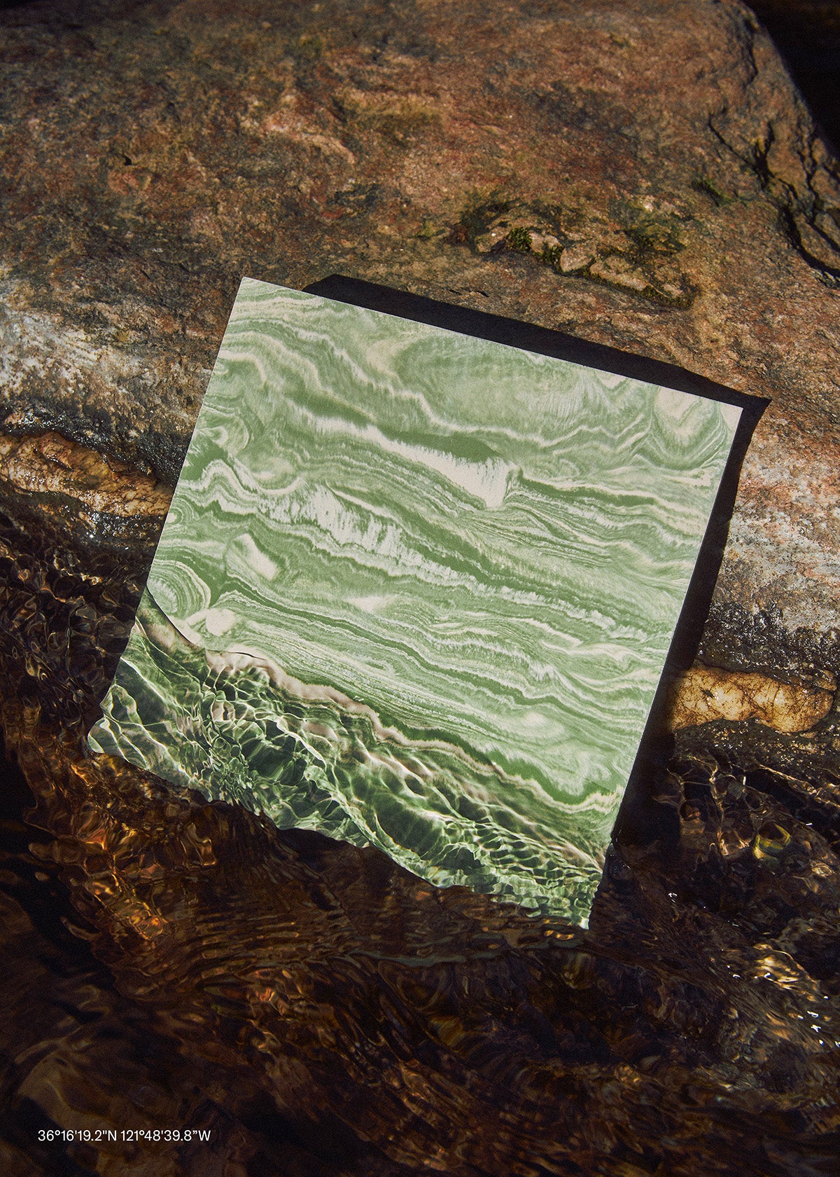 Green marble stone on a textured brown surface