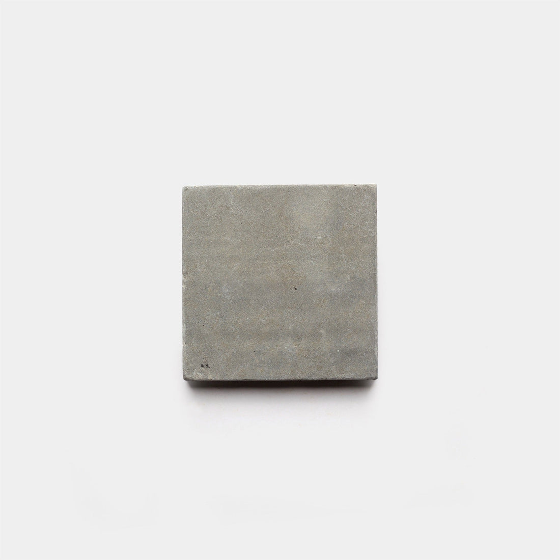 A single Basilica 6x6 + Honed concrete tile sample by Zia Tile is centered on a plain white background, showcasing the brand's modern, handcrafted elegance.