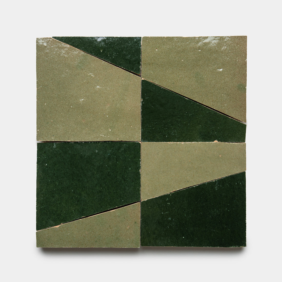 The Atlas 4 by Zia Tile features four square ceramic tiles arranged in a grid, each split diagonally into olive and dark green sections for a bold geometric pattern on a white background.