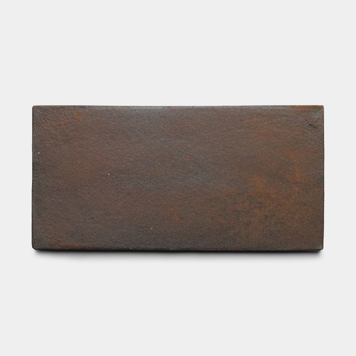 A single rectangular, reddish-brown brick with a rough texture, photographed on a white background, resembles the 6.5x13 Rectangle + Madera sample by Zia Tile.