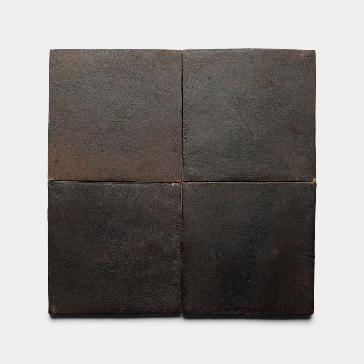 Four 8x8 Square + Oscura ceramic samples from Zia Tile, featuring a matte finish and dark brown shade with a subtly uneven texture, are arranged in a grid on a white background.