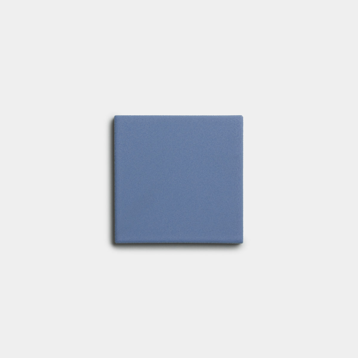 A single Aizome 4x4 solid blue square tile from Zia Tile is centered on a plain light gray background.