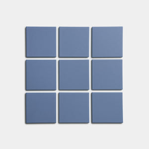 Sixteen blue square tiles from Zia Tile’s Aizome 4x4 collection arranged in a clean 4-by-4 grid on a plain white background.