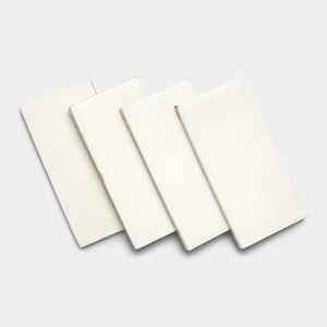 Four Albar 4x8 Rectangle tiles by Zia Tile in off-white are displayed in a slightly overlapping, fanned-out arrangement on a light gray background.