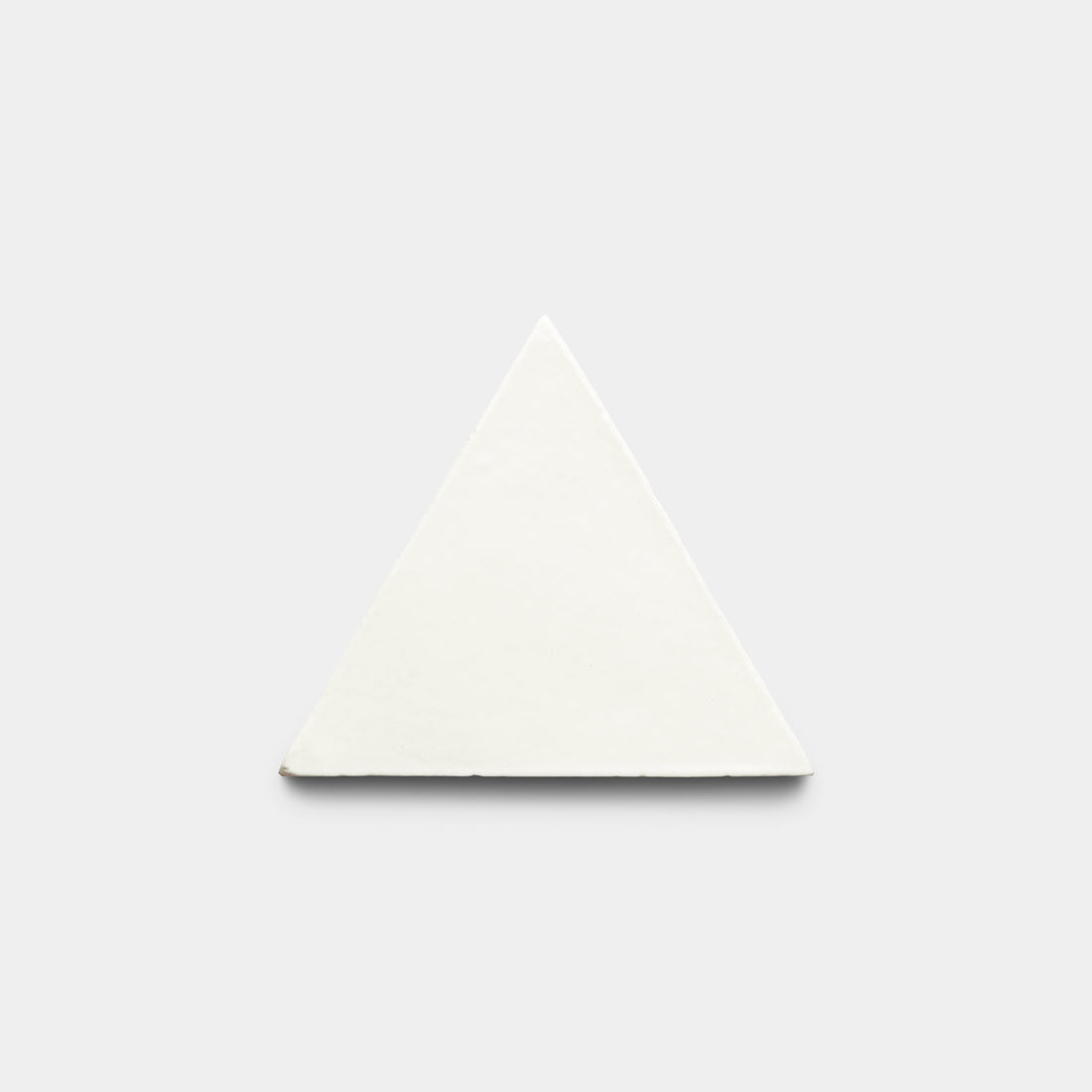 The Albar Triangle by Zia Tile, a white solid equilateral triangle, is centered on a plain light gray background.