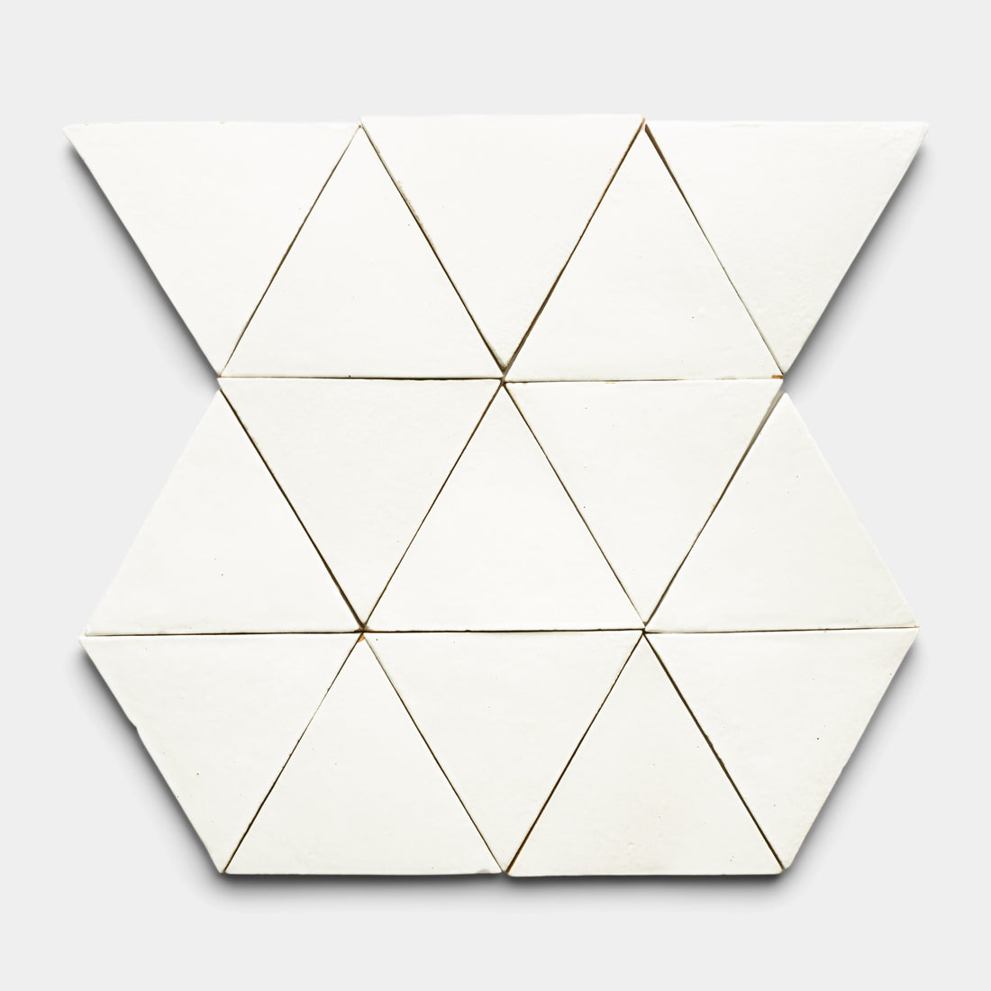 The Albar Triangle by Zia Tile features twelve white triangular pieces arranged in a hexagonal pattern on a light gray background.