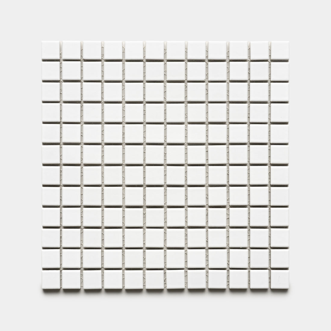 The Zia Tile Alpha White 1x1 features a grid of small, evenly spaced white square tiles arranged in rows and columns on a light gray background.