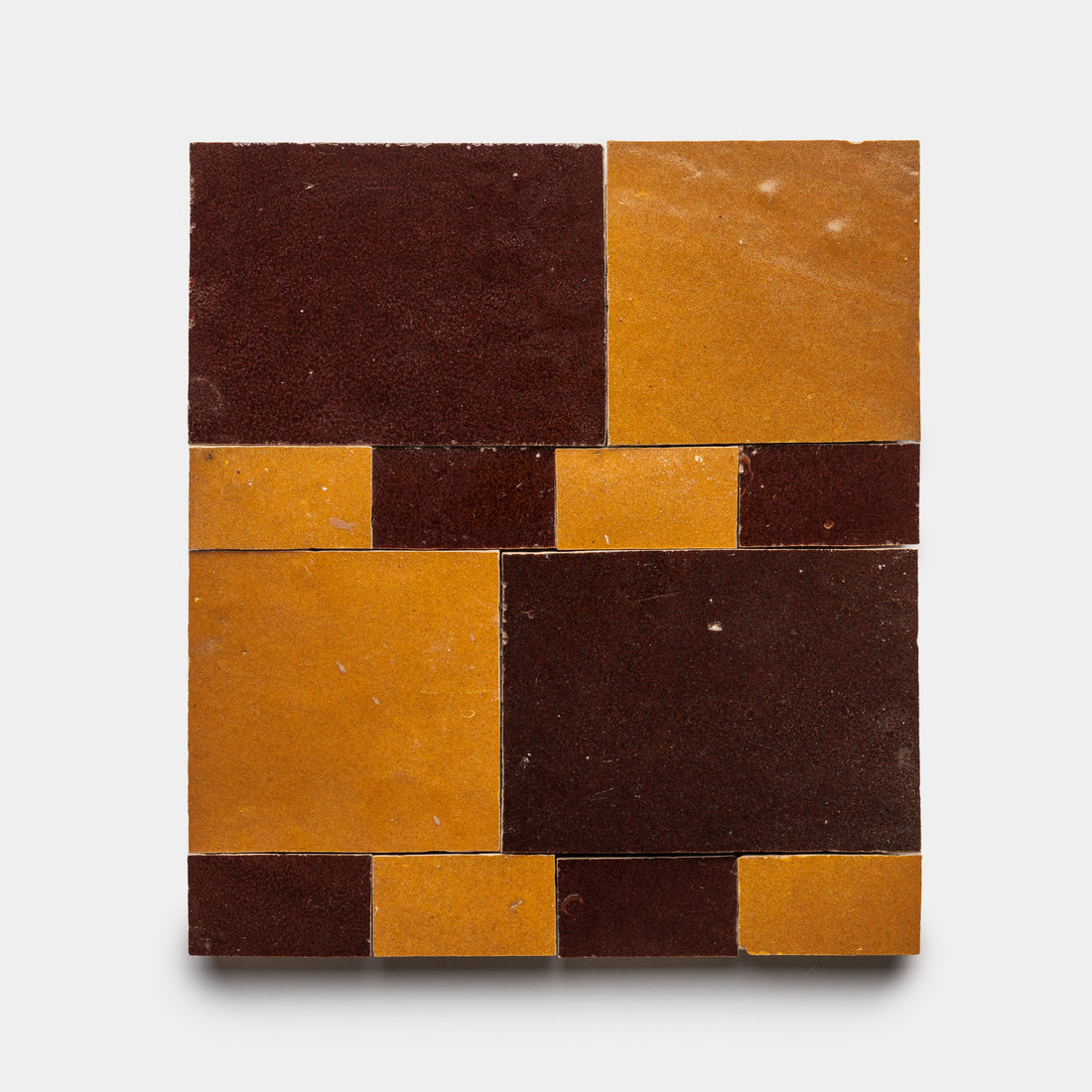 The Xylem 2 by Zia Tile features a modern, abstract pattern with dark brown and mustard yellow rectangles arranged geometrically on a white background.