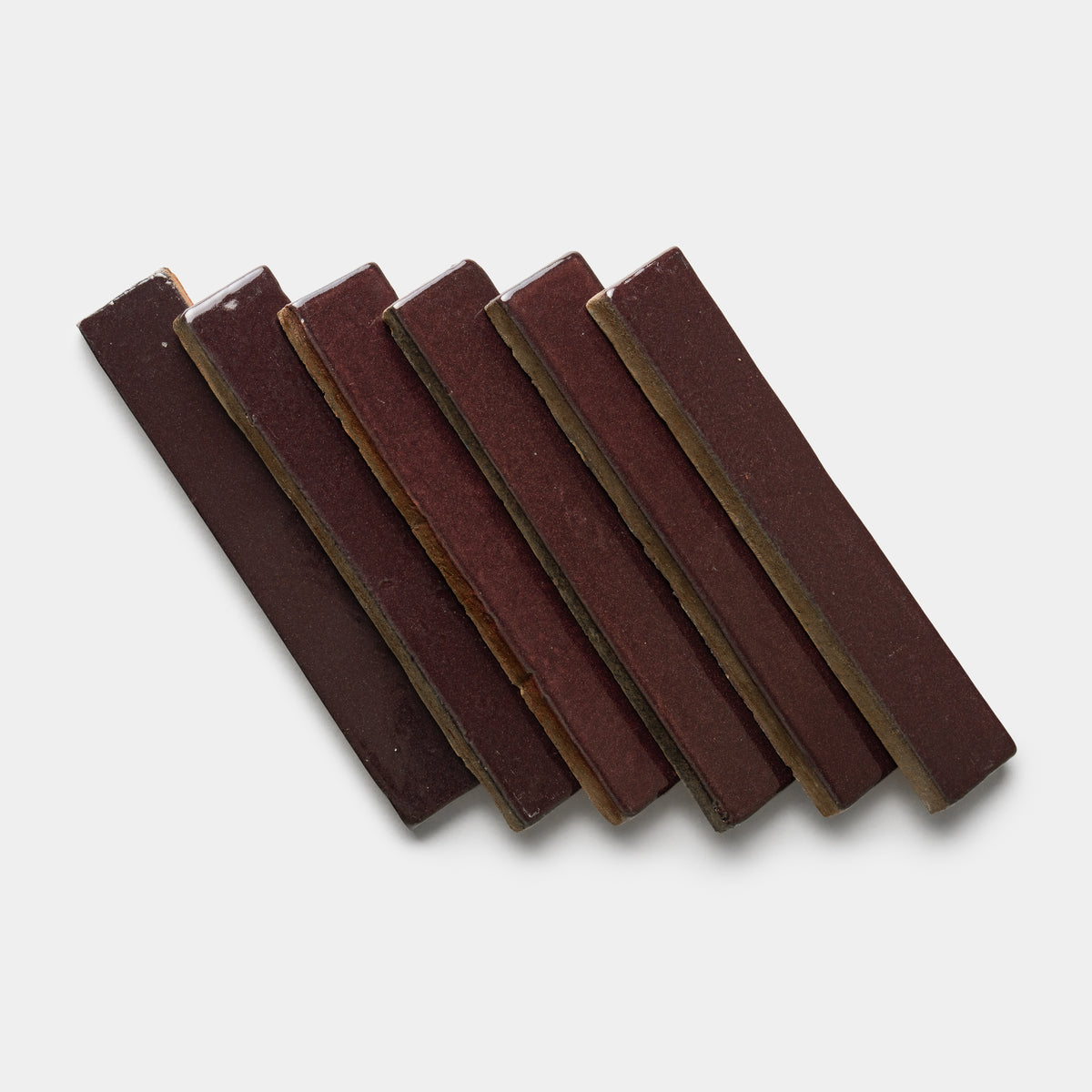 Six Zia Tile Ancho Mini Bars are arranged diagonally in a neat, overlapping row on a plain white background.
