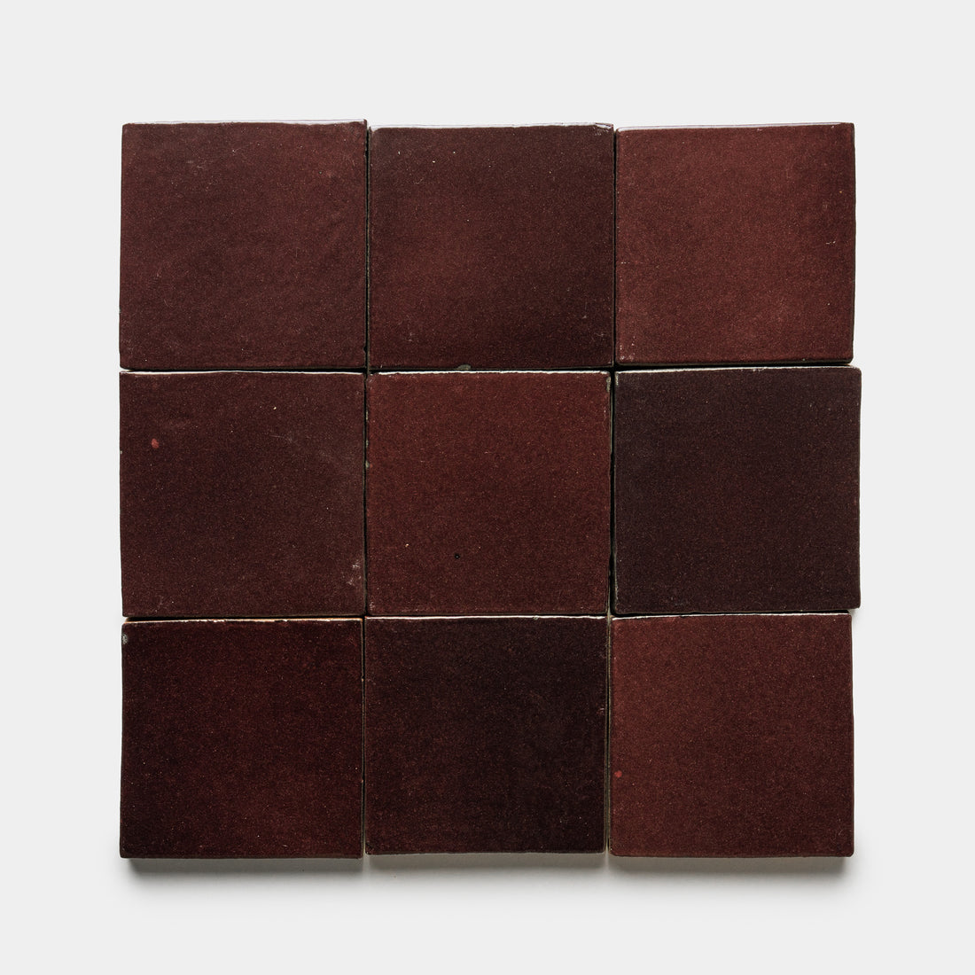 Nine Ancho 4x4 Square matte dark red ceramic tiles by Zia Tile are arranged in a 3x3 grid on a plain white background.
