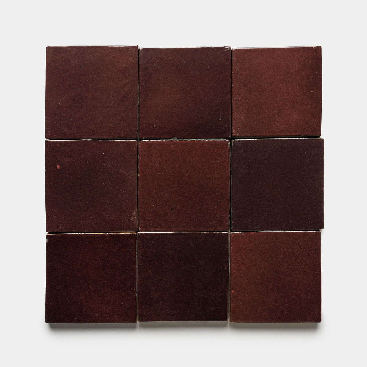 Nine Ancho 4x4 Square matte dark red ceramic tiles by Zia Tile are arranged in a 3x3 grid on a plain white background.