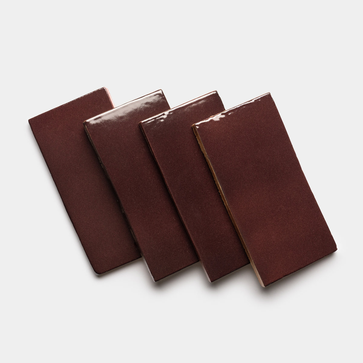 Four glossy, rectangular Ancho 4x8 Rectangle tiles by Zia Tile are arranged in a slightly overlapping diagonal row on a plain white background.