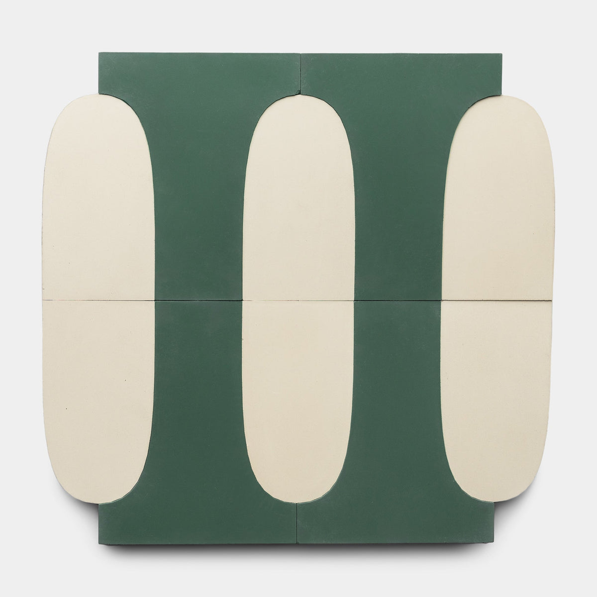 Experience Arco Noble Green + Bone by Zia Tile: a geometric abstract design with four rectangular panels. Cream ovals, bordered by deep green shapes on a neutral background, create a symmetrical, minimalist pattern inspired by handmade tiles.