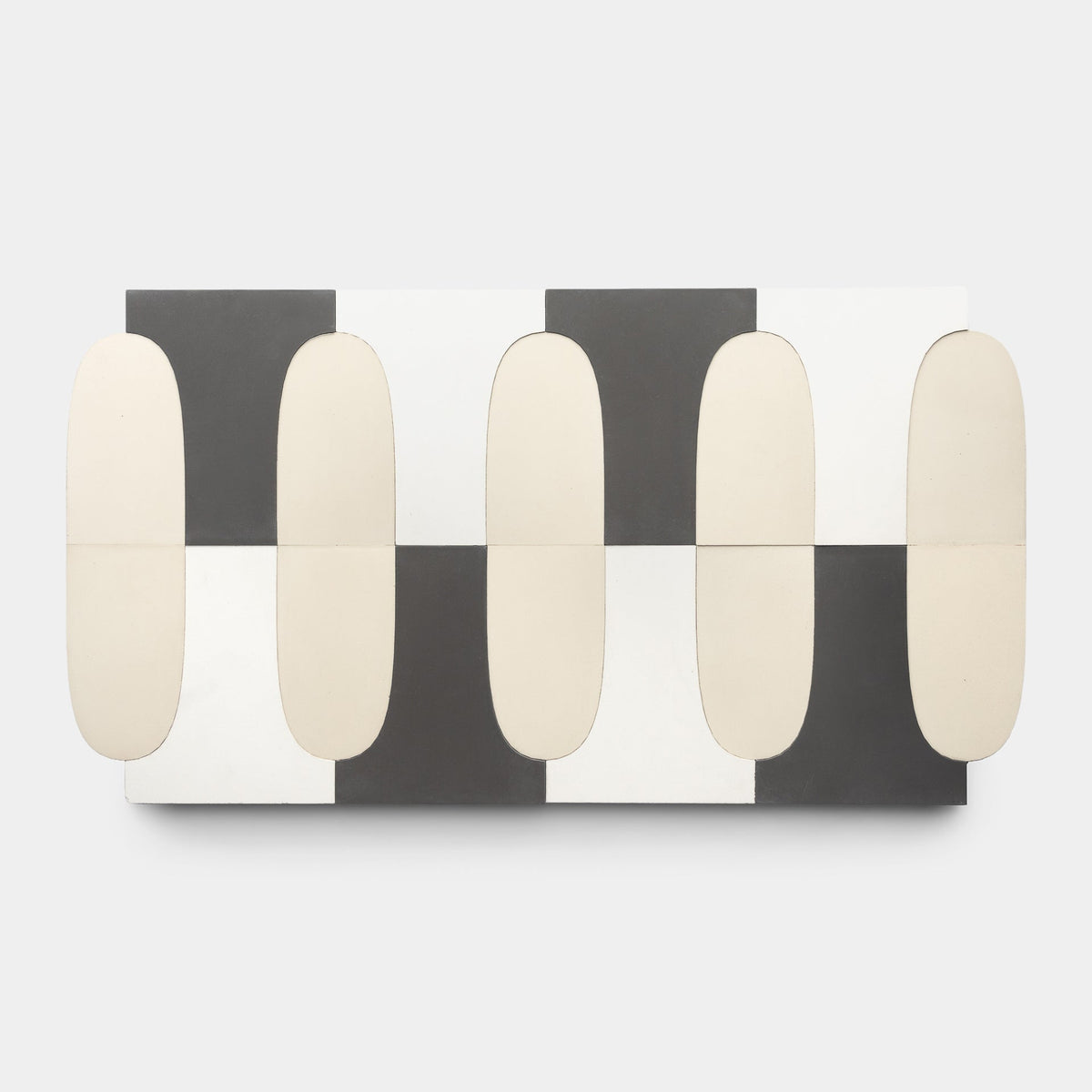 The Arco White + Black + Bone Sample by Zia Tile features alternating black, white, and bone square tiles with elongated beige ovals, creating a modern geometric wall art pattern inspired by handmade tile design.