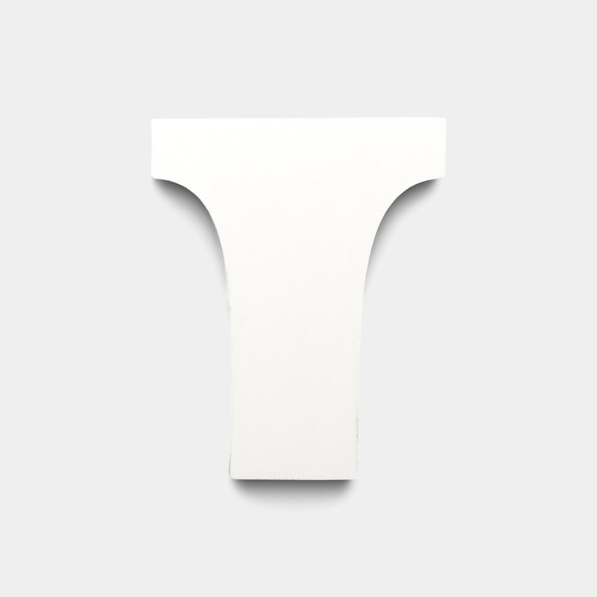 The Arco White + Bone, Sample by Zia Tile is a white, T-shaped handmade tile with curved inner edges, displayed on a plain light gray background.