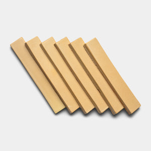 Six rectangular beige Arroyo Mini Bars by Zia Tile are arranged diagonally in a neat, overlapping row on a white background.