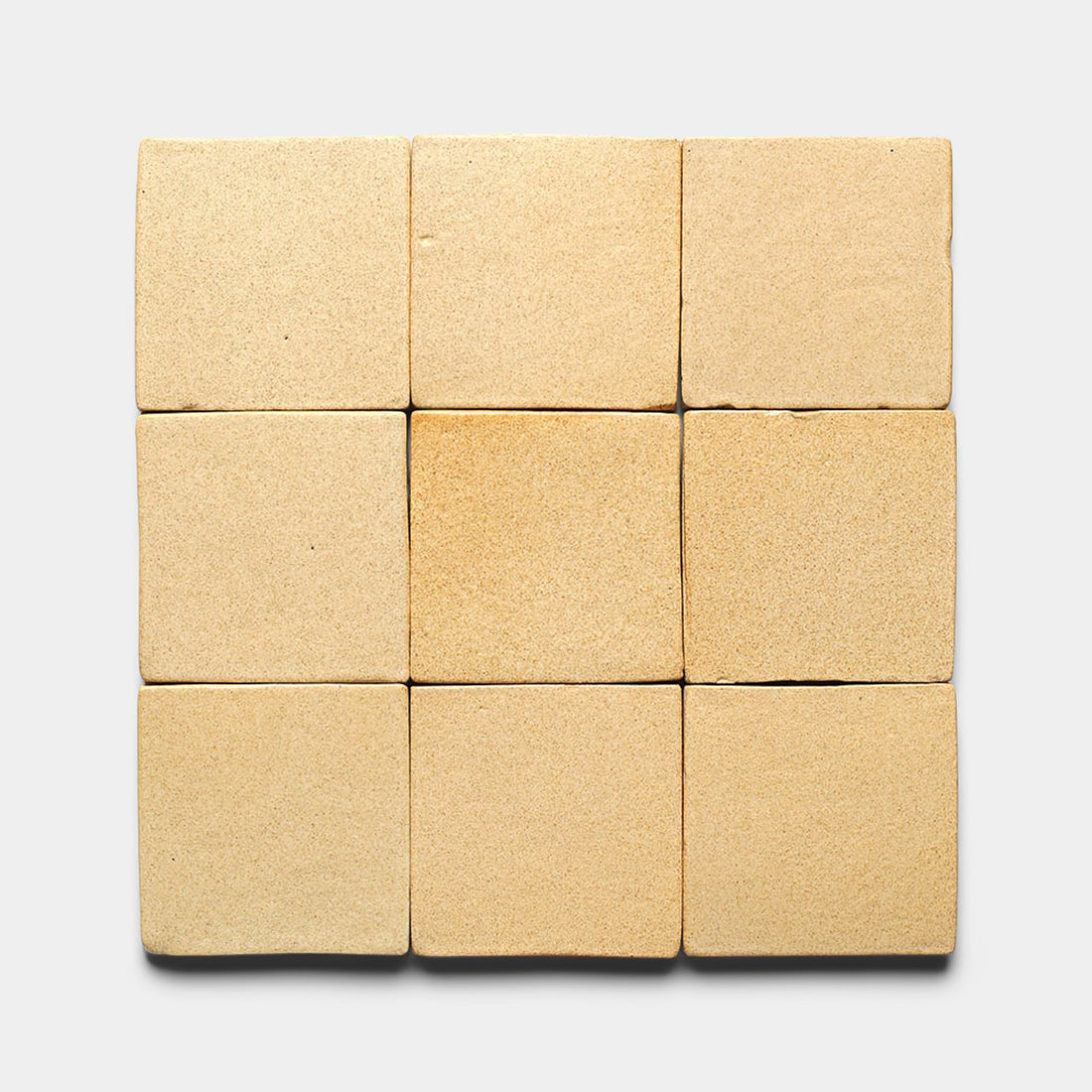 Nine Arroyo 4x4 Square tiles by Zia Tile are arranged in a 3x3 grid on a light gray background, showcasing their handmade texture and subtle color variation, inspired by San Miguel de Allende.