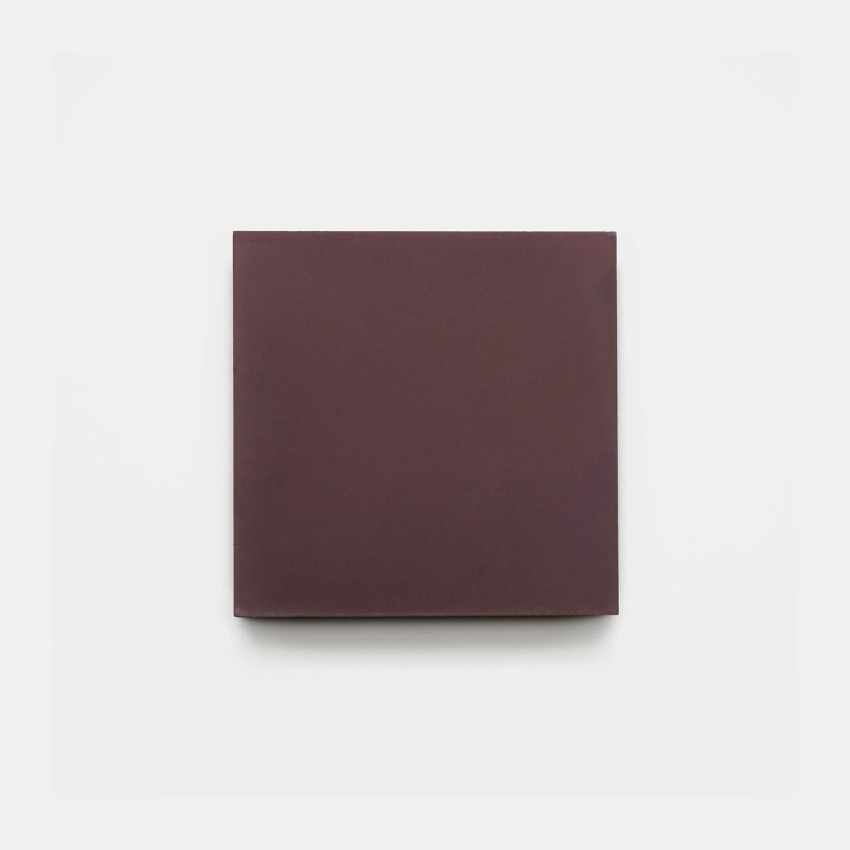 Aubergine 4x4 tile sample by Zia Tile—a handmade, square, solid tile in deep maroon—is centered on a plain white background.