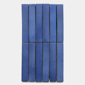 Ten Azul Mini Bar tiles by Zia Tile, featuring a rectangular blue ceramic design, are arranged in two vertical rows of five side by side on a light gray background.