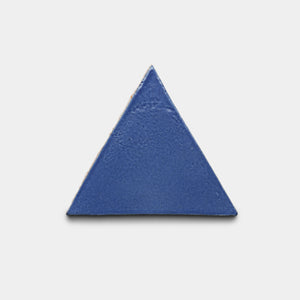 The Azul Triangle tile by Zia Tile is a solid blue ceramic triangle with a smooth, slightly glossy finish, shown on a plain white background.