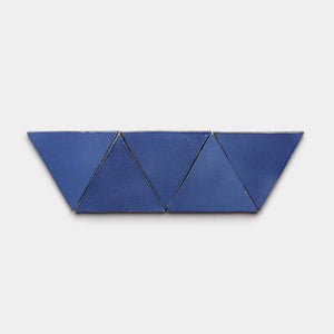 Five Azul Triangle tiles by Zia Tile, blue ceramic pieces arranged in a horizontal row on a white background, forming a trapezoid-like shape with two inverted triangles in the center.
