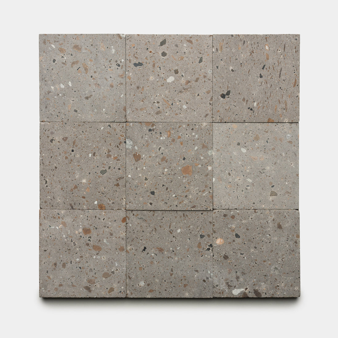 Nine Badlands 6x6 terrazzo tiles by Zia Tile, featuring gray tones with brown, tan, and black stone chips, are arranged in a 3x3 grid on a white background.