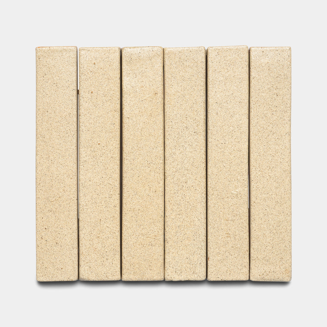 Six Zia Tile Baja Mini Bar rectangular beige bricks are arranged vertically side by side on a light gray background, forming a neat, evenly spaced row.