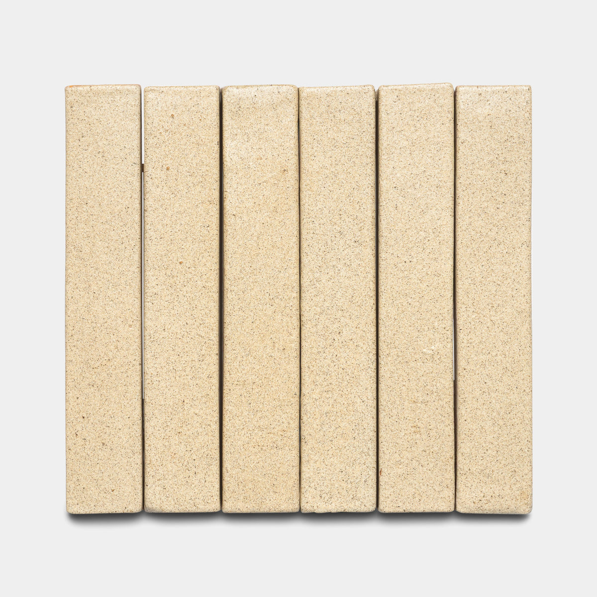 Six Zia Tile Baja Mini Bar rectangular beige bricks are arranged vertically side by side on a light gray background, forming a neat, evenly spaced row.