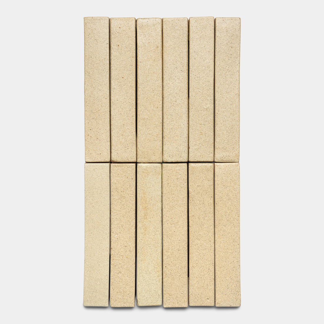 Twelve Zia Tile Baja Mini Bar beige rectangular tiles are arranged vertically in two rows of six against a plain white background.