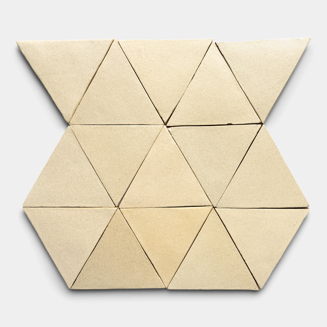 The Baja Triangle by Zia Tile features ten beige triangular tiles arranged symmetrically on a light gray background, creating a striking geometric pattern with neatly aligned shapes.