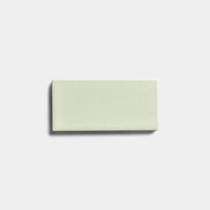 A single Balsam 2x4 ceramic tile by Zia Tile, featuring a matte finish in light green, is centered on a plain white background with a subtle shadow on its left side.