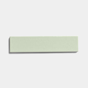 A single Balsam 2x8 rectangular ceramic tile by Zia Tile, light green with a matte, smooth surface, is displayed on a plain white background.