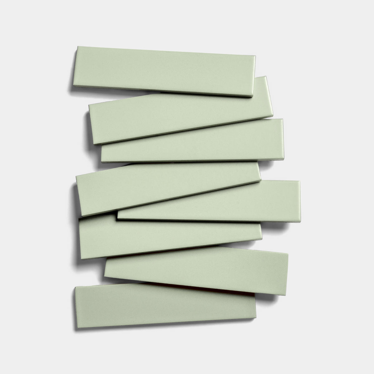 Nine Balsam 2x8 light green matte ceramic tiles by Zia Tile are stacked in a staggered, alternating pattern against a plain white background.