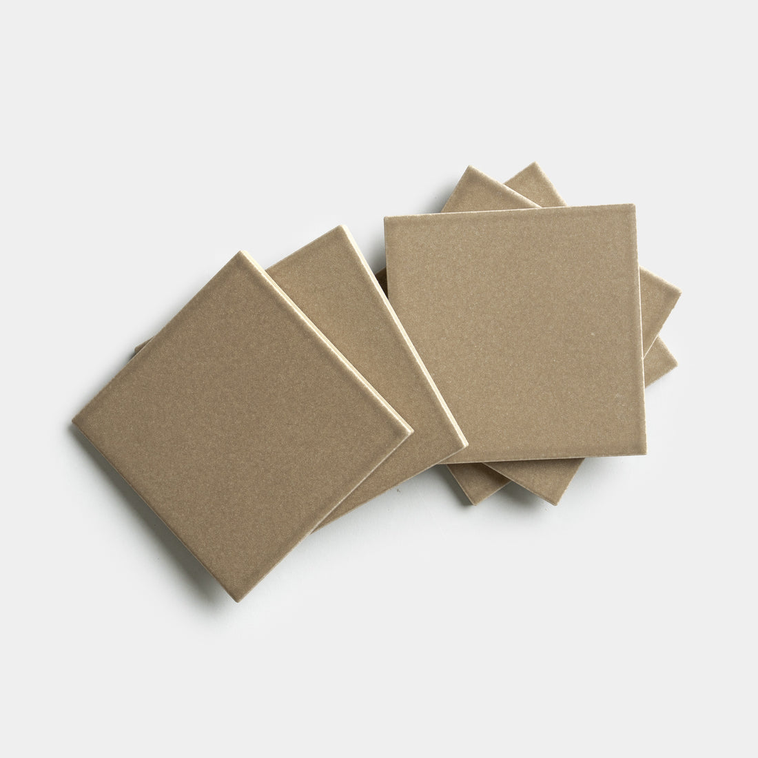 Six Zia Tile Barley 4x4 square beige ceramic tiles are displayed in a fanned-out, overlapping pattern on a plain white background.