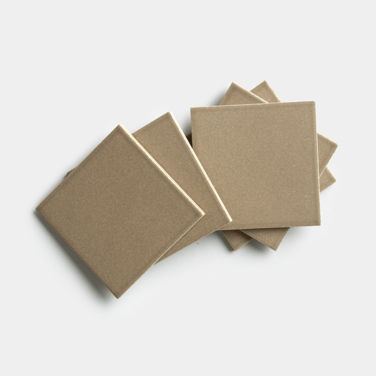 Six Zia Tile Barley 4x4 square beige ceramic tiles are displayed in a fanned-out, overlapping pattern on a plain white background.