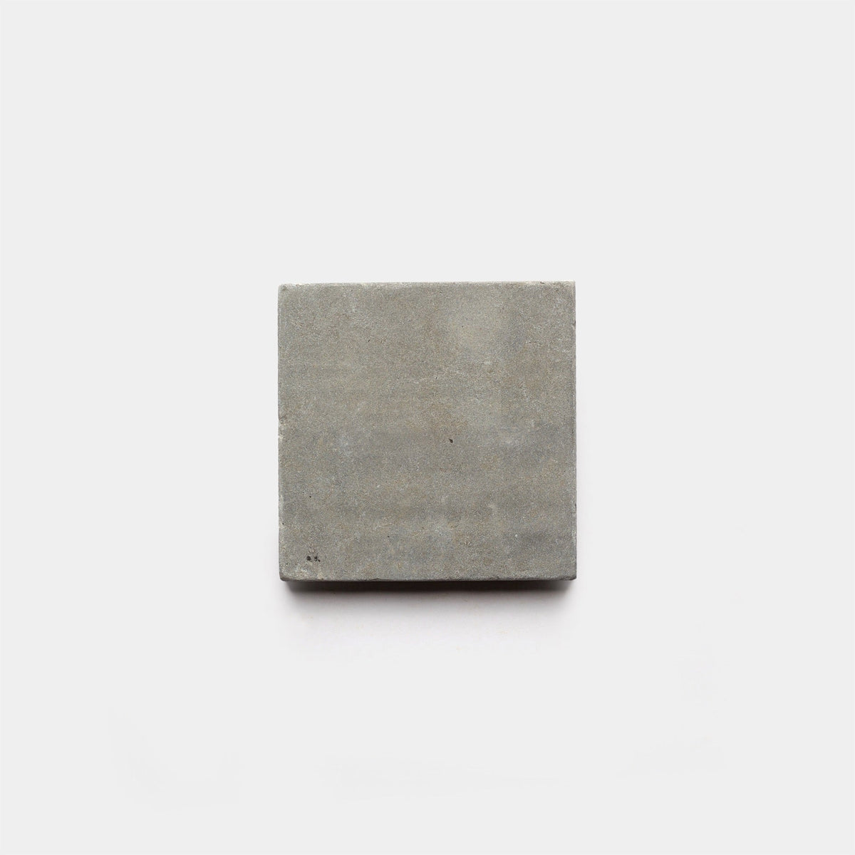 A single Basilica 6x6 + Honed concrete tile sample by Zia Tile is centered on a plain white background, showcasing the brand's modern, handcrafted elegance.