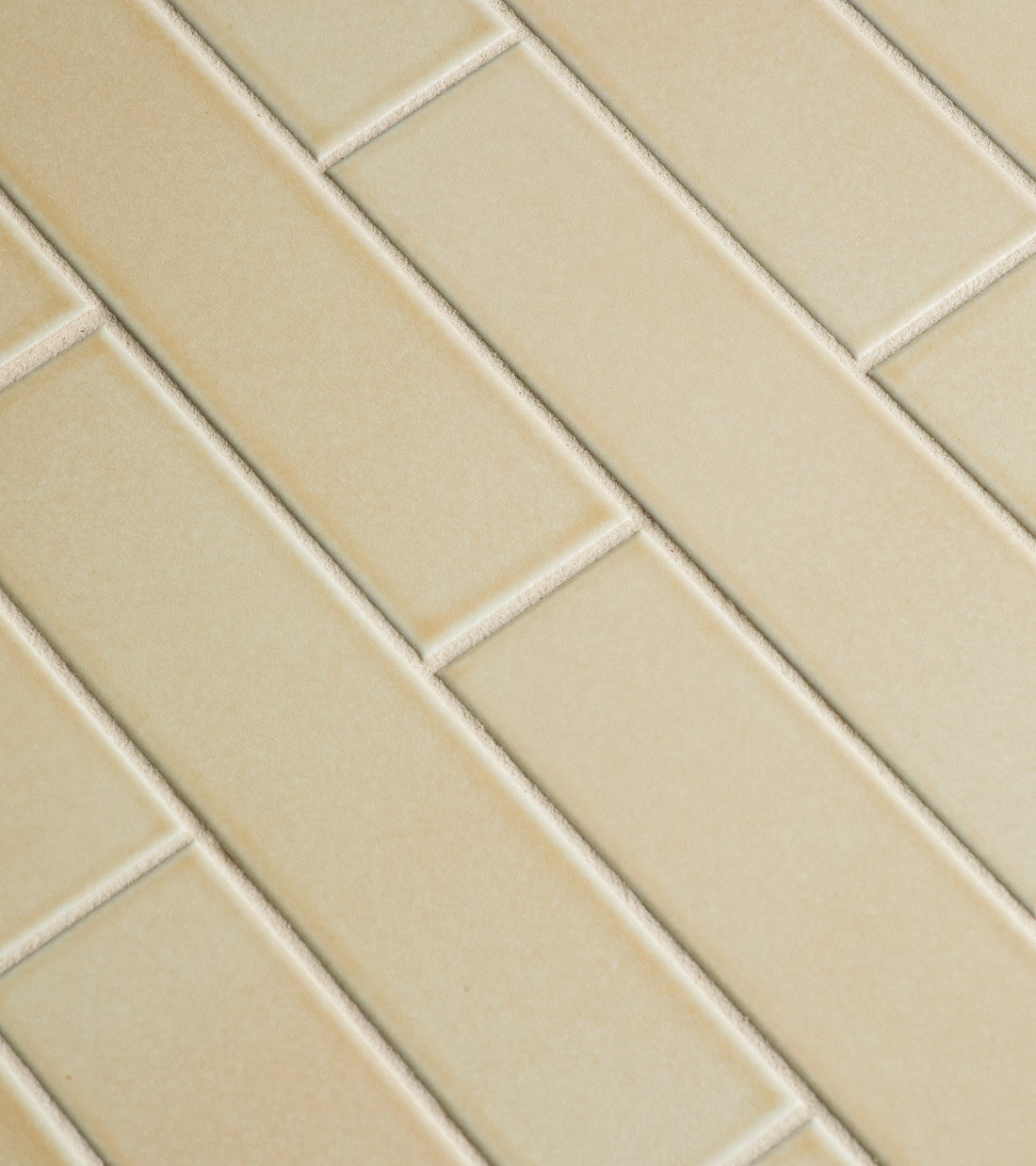 Close-up of Zia Tile's Birch 2x8 beige rectangular tiles arranged in a staggered brick pattern with visible grout lines. The smooth, glossy surface highlights the modern design.
