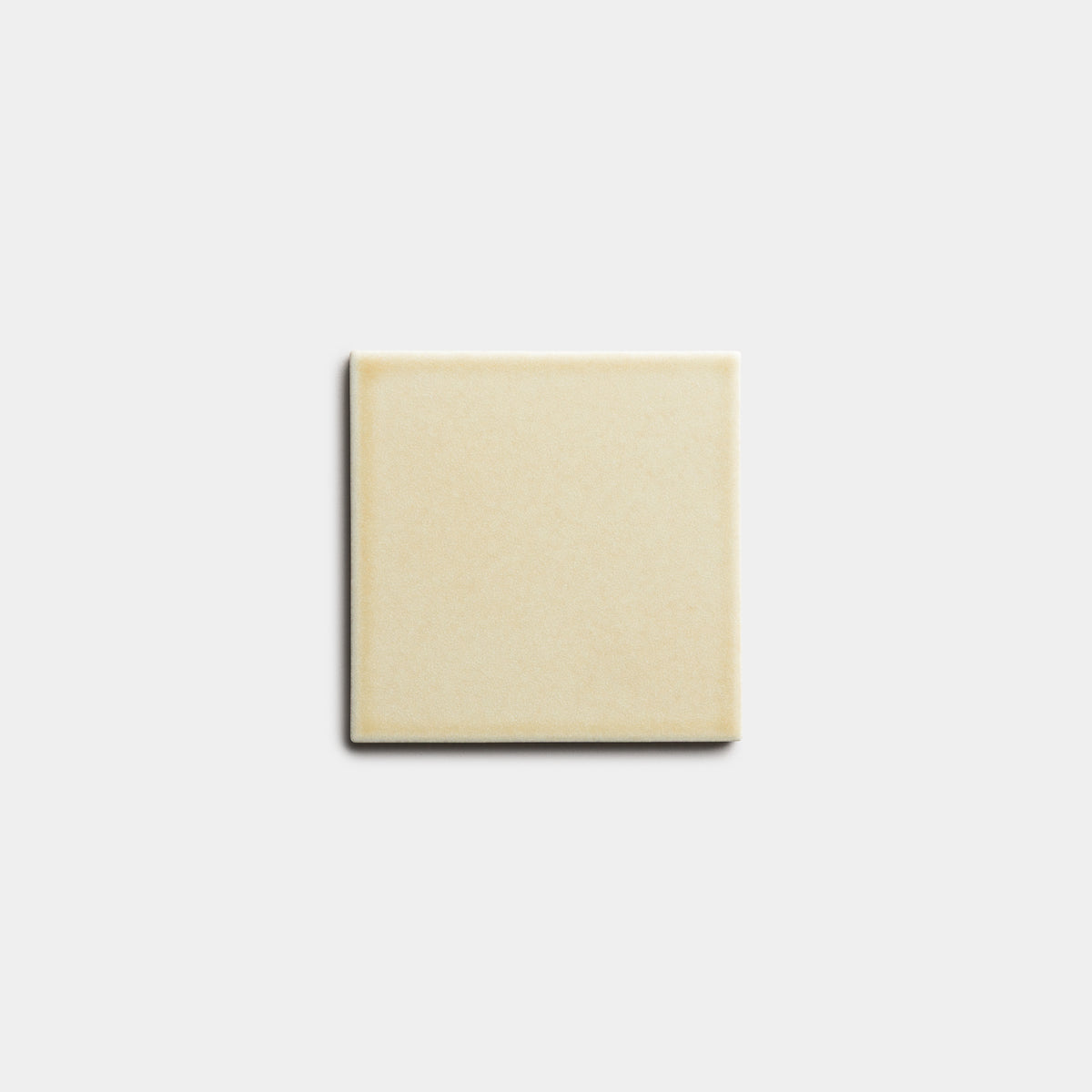 A single Zia Tile Birch 4x4 square, beige ceramic tile is centered on a plain, light gray background.
