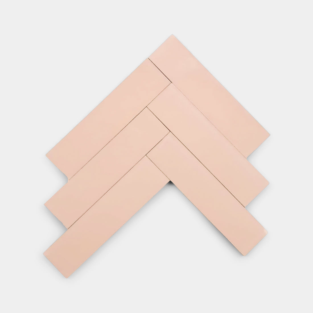 Five rectangular Bisbee Pink 2x8 tiles by Zia Tile are arranged in a herringbone pattern on a white background, highlighting the brand's signature style.