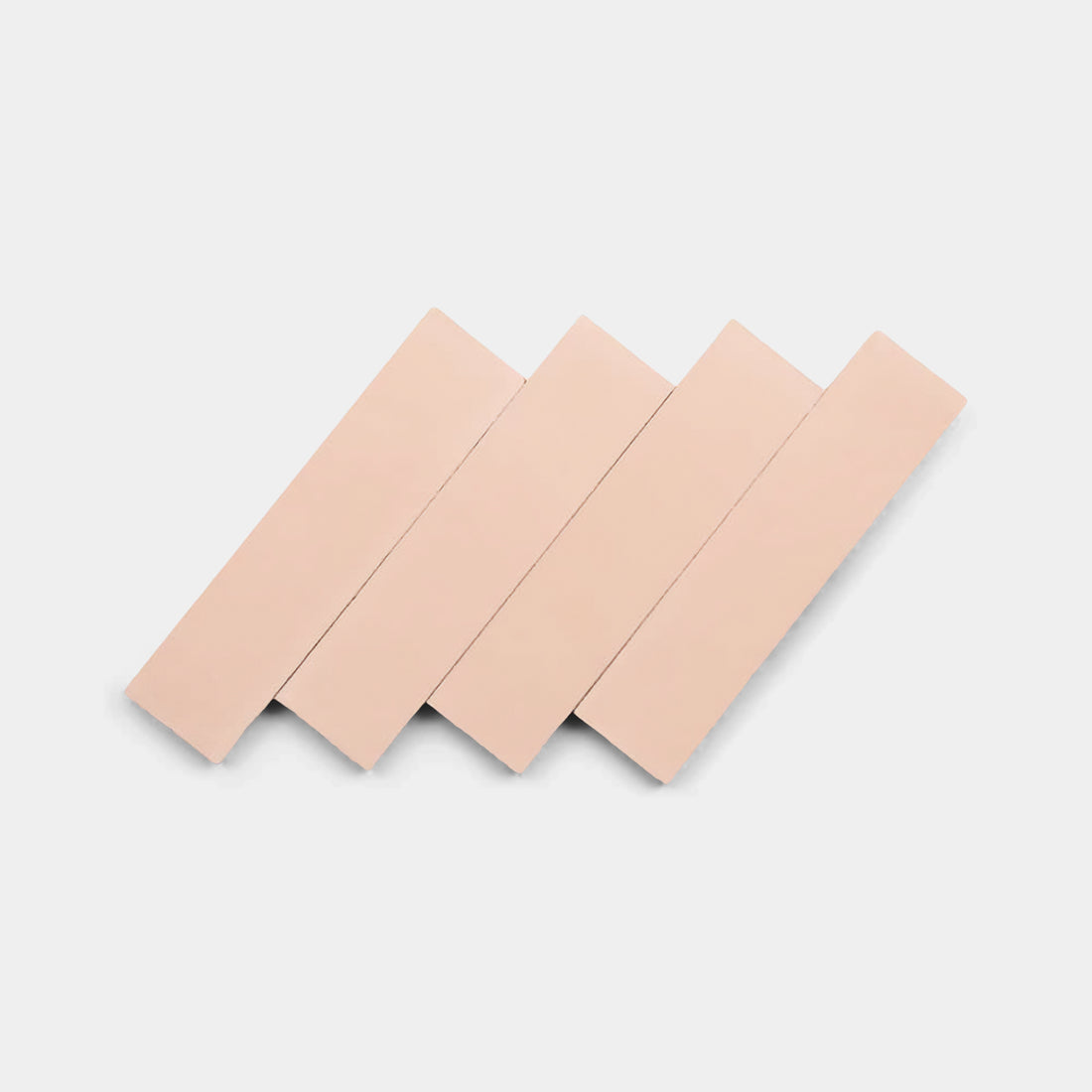 Four Bisbee Pink 2x8 tiles from Zia Tile are arranged diagonally and overlapping each other on a plain white background, resembling the geometric pattern of handmade tilework.