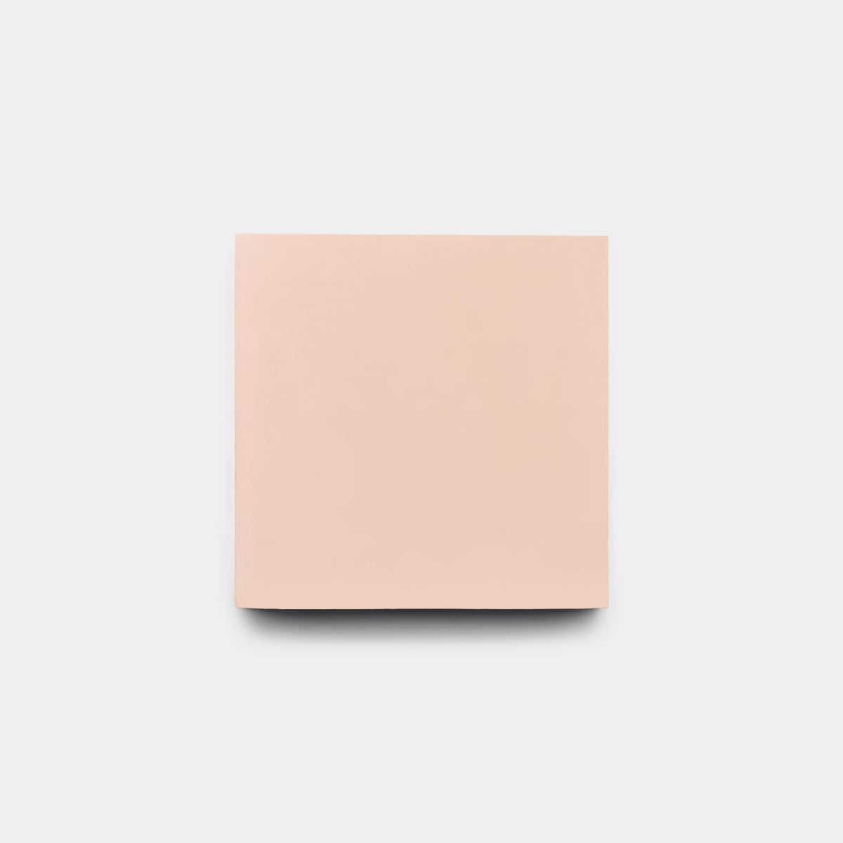 A plain, light pink Bisbee Pink 4x4 cement tile from Zia Tile is centered on a white background with a subtle shadow beneath—perfect for a modern kitchen backsplash.