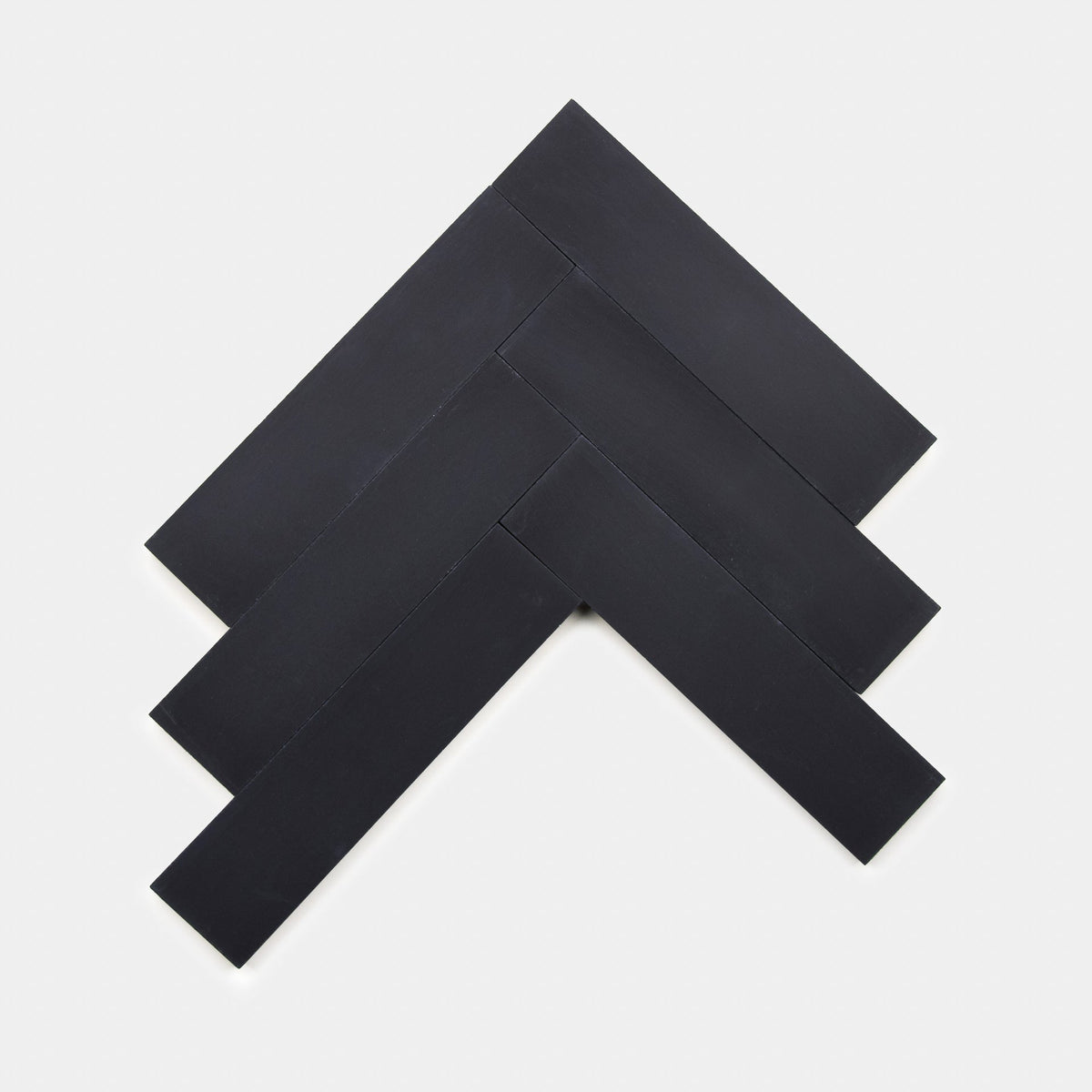 Five “Black 2x8, Sample” tiles by Zia Tile are arranged in a staggered geometric pattern on a white background, forming an arrow-like shape pointing upward and to the right.