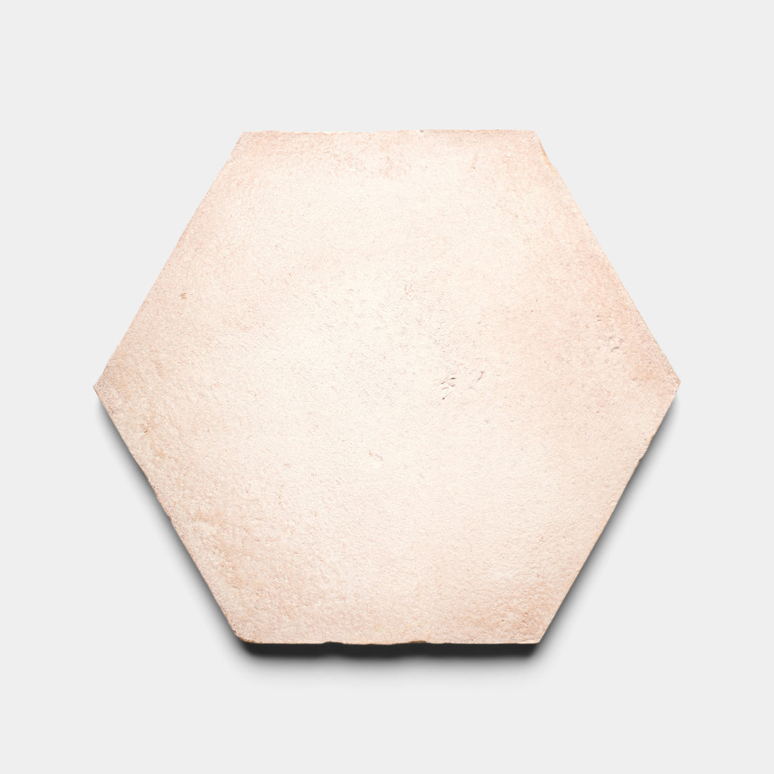 A single, light beige hexagonal tile with a slightly rough texture, displayed against a plain white background.