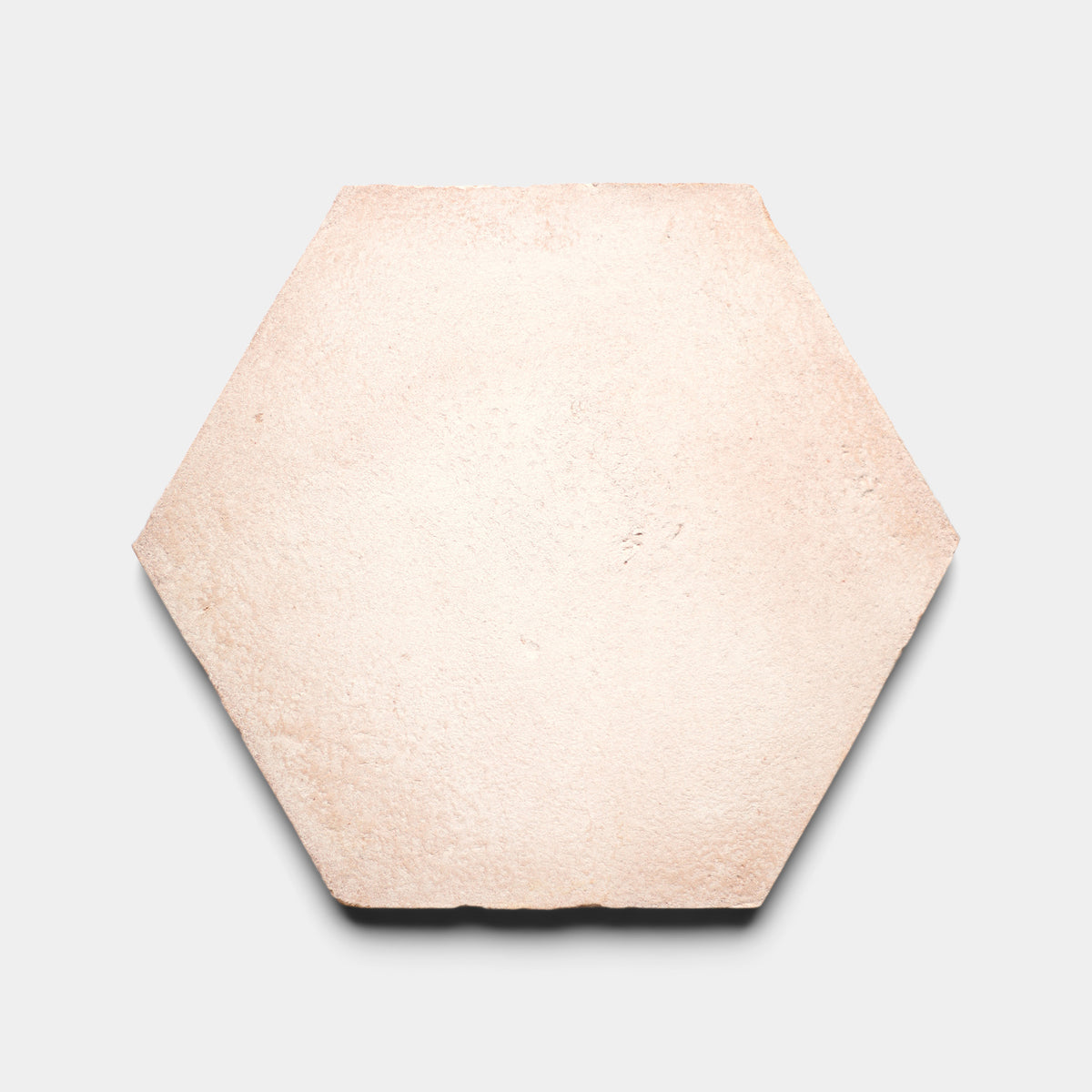 A single, light beige hexagonal tile with a slightly rough texture, displayed against a plain white background.