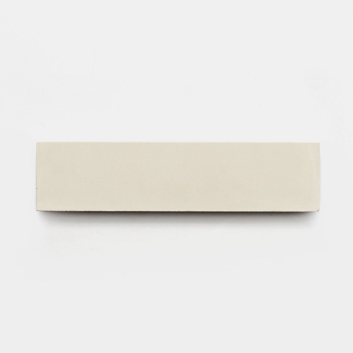 A rectangular, flat, light beige tile sample—Zia Tile’s Bonsai 2x8—is centered on a plain white background in a minimalist style.