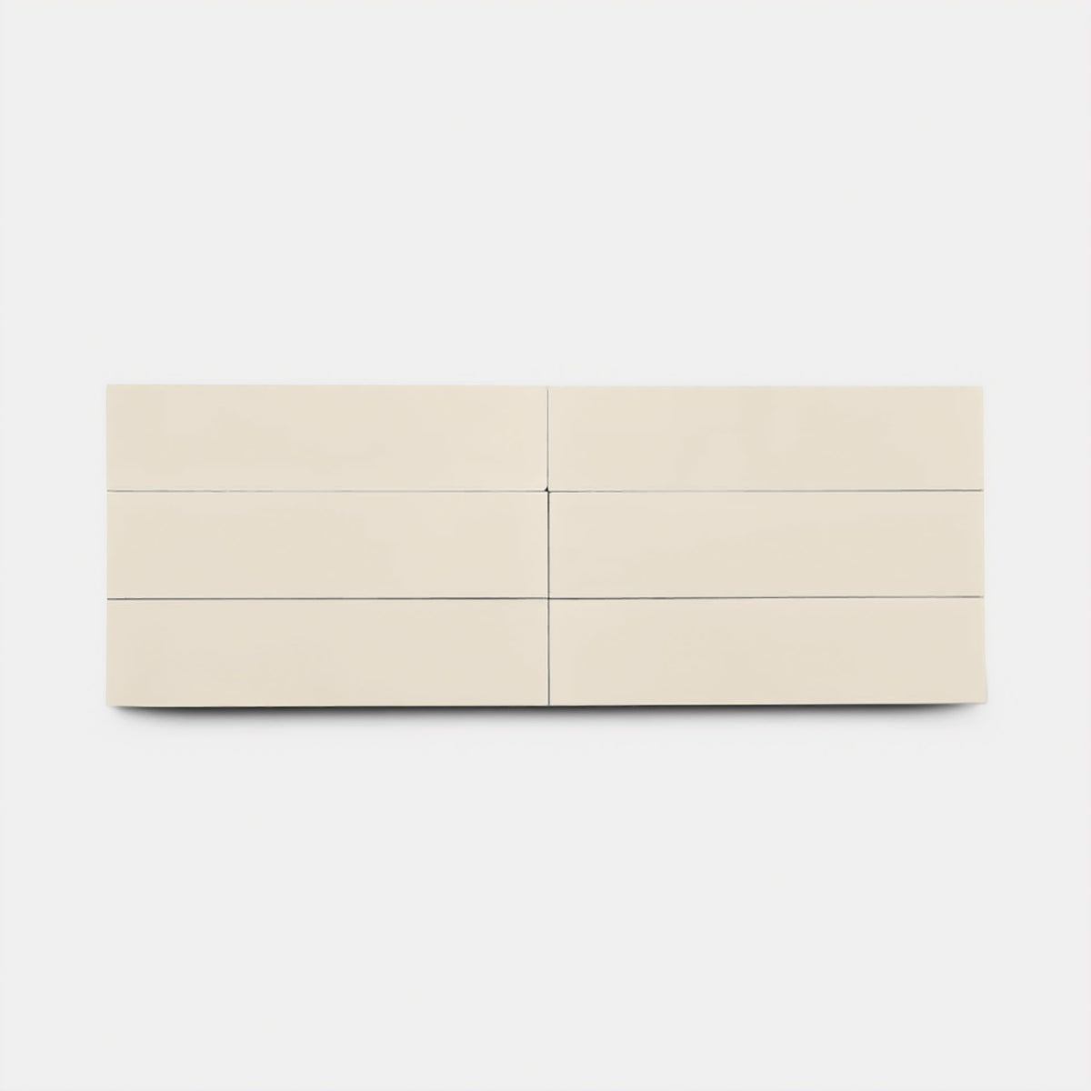 A sample of Bonsai 2x8 by Zia Tile, featuring a smooth off-white finish and minimalist design with clean lines, is displayed against a plain white background.
