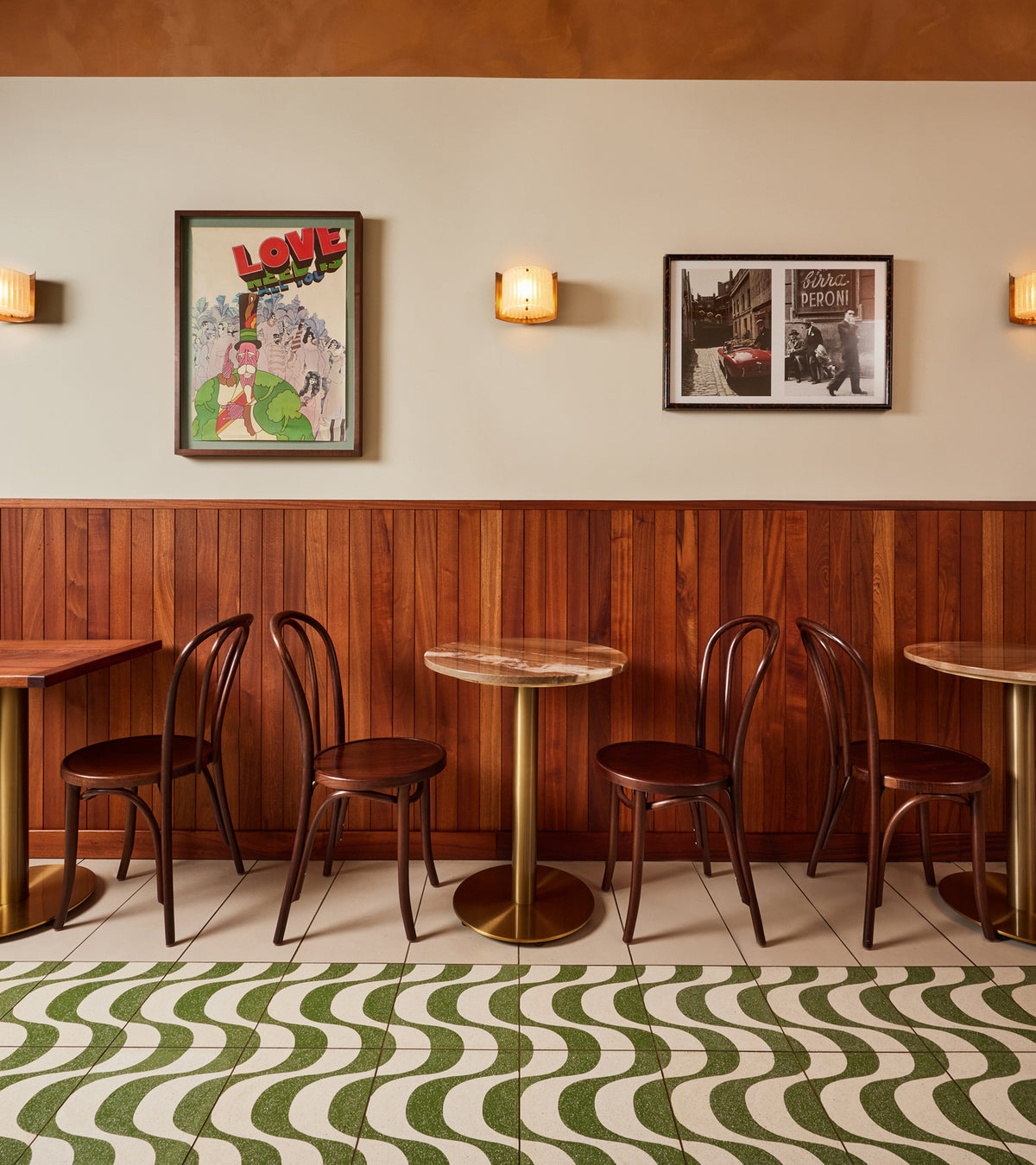 A room with tables and chairs, featuring elegant Bossa Nova Saguaro 12x12 terrazzo cement tile flooring by Zia Tile.