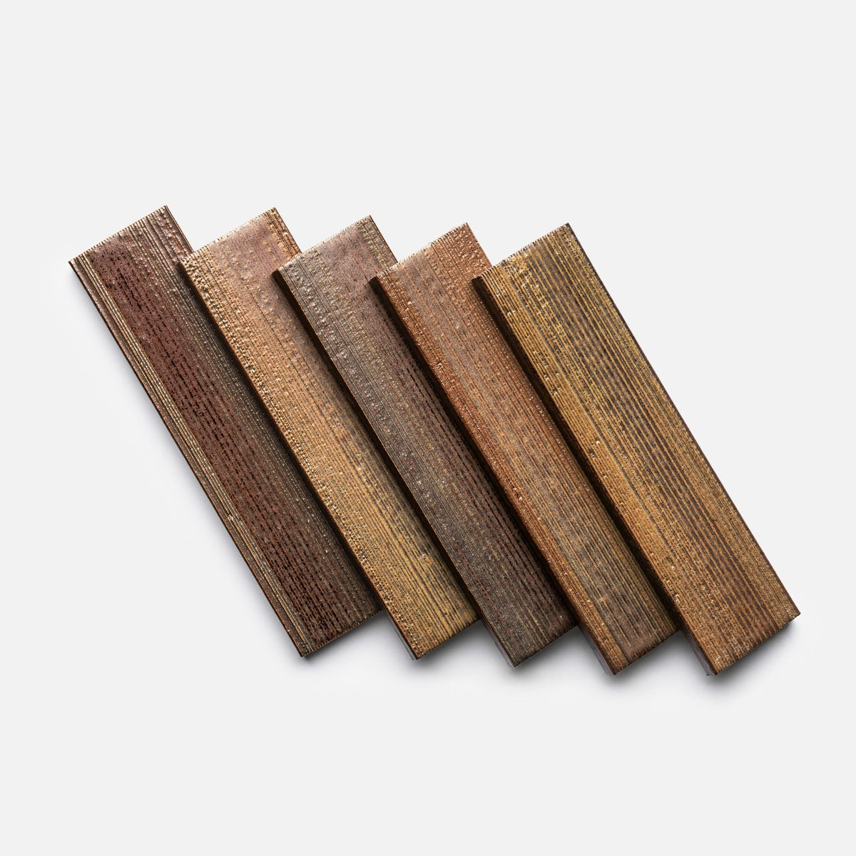 Five Buckeye + Etched samples from Zia Tile, each with textured, grooved surfaces in different brown shades, are displayed fanned out on a plain white background.
