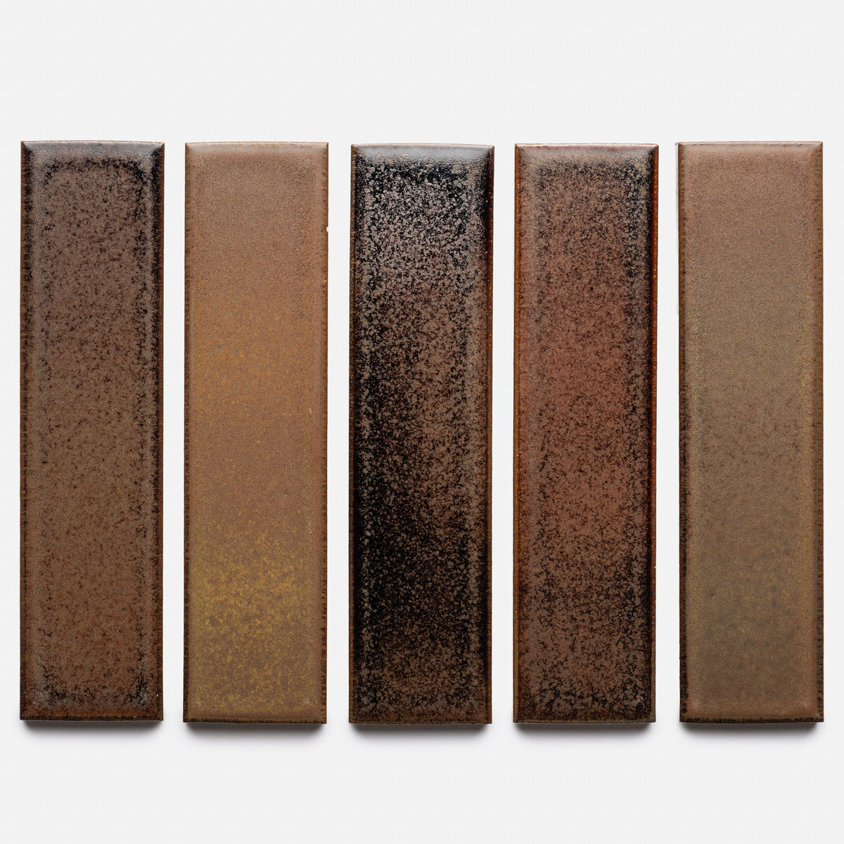 Five Buckeye + Flat ceramic tile samples by Zia Tile, rectangular and brown with a speckled, slightly glossy finish, are arranged vertically side by side on a plain light background.
