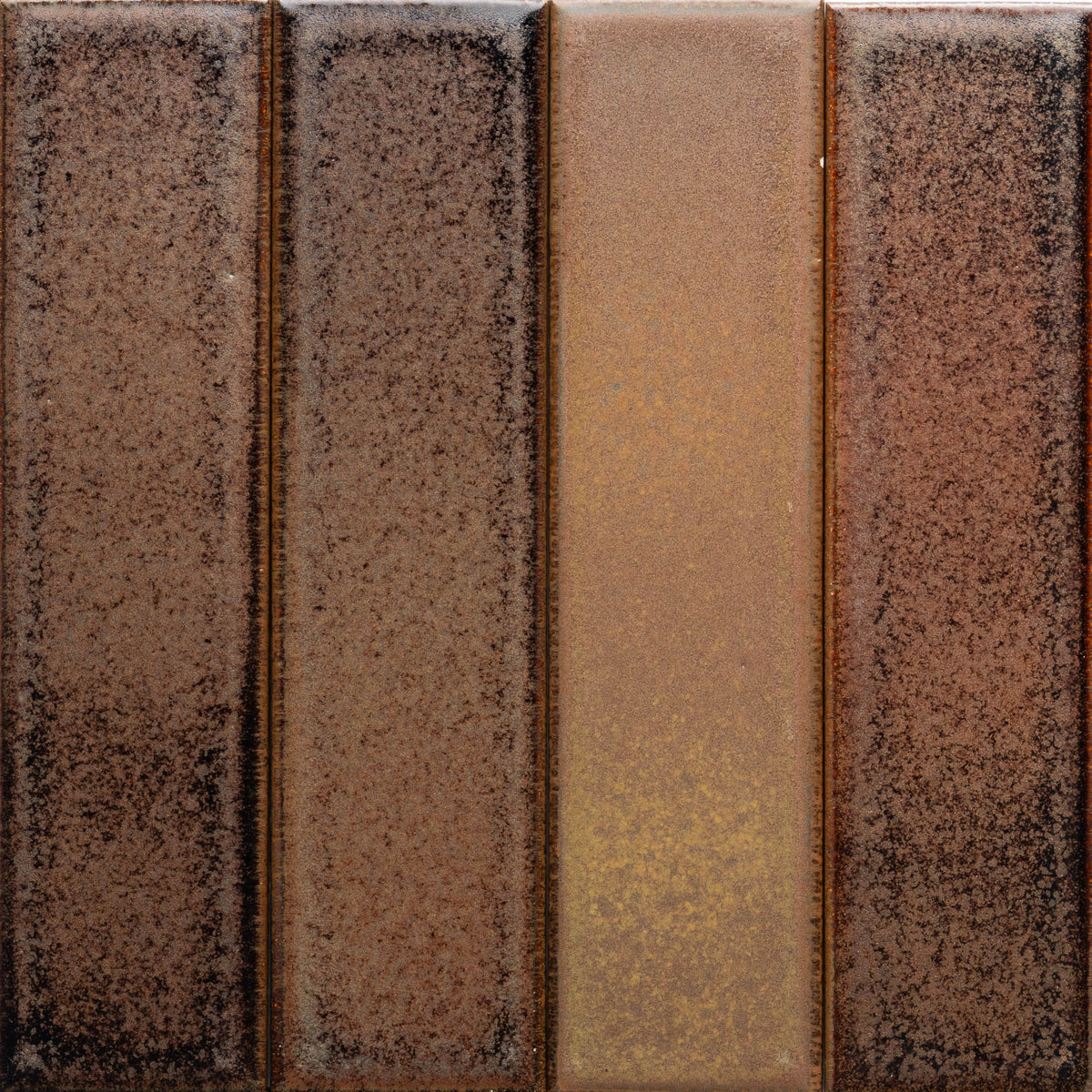 A close-up of Zia Tile's Buckeye + Flat Sample shows four vertical rectangular sections in brown tones with a rustic, weathered, and speckled finish.